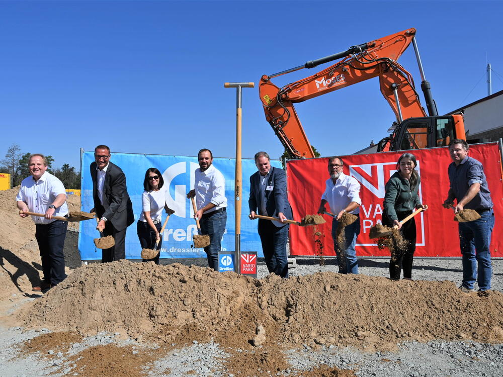Acht Personen beim Spatenstich vor Bannern de rFirmen Dreßler Bau und VarioPark