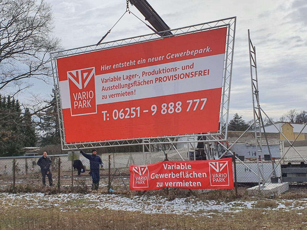 Kran beim Aufbau eines Riesenwerbeschild mit VarioPark-Werbung